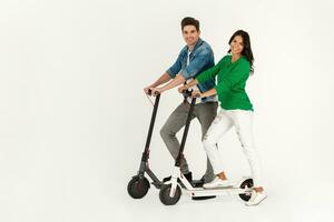 a couple riding on electic kick scooter isolated on white studio background photo