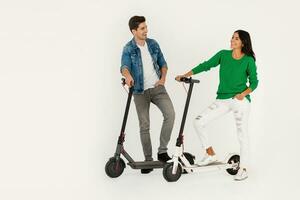 a couple riding on electic kick scooter isolated on white studio background photo