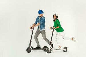 a couple riding on electic kick scooter isolated on white studio background photo