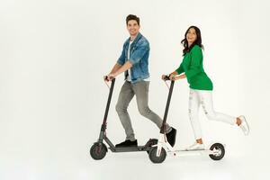 a couple riding on electic kick scooter isolated on white studio background photo