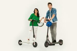 a couple riding on electic kick scooter isolated on white studio background photo