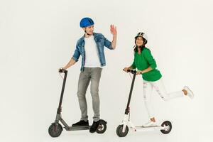 a couple riding on electic kick scooter isolated on white studio background photo