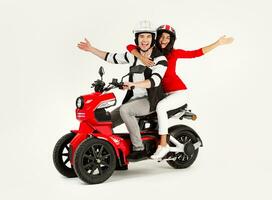 young attractive couple riding an electric motorbike scooter happy having fun together photo