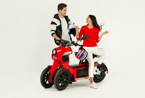 young attractive couple riding an electric motorbike scooter happy having fun together photo