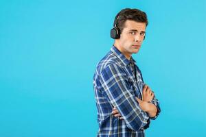 elegante joven hombre escuchando a música en inalámbrico auriculares foto