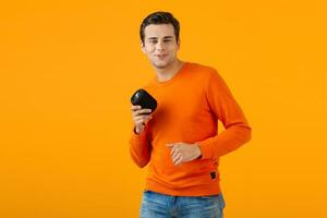 stylish young man holding wireless speaker photo