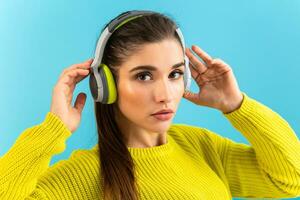 stylish young woman holding listening to music in headphones photo