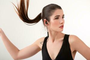 attractive woman in jogging black top listening to music on earphones photo