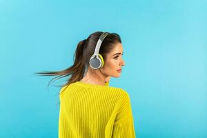 stylish young woman holding listening to music in headphones photo