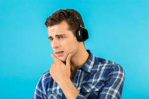 elegante joven hombre escuchando a música en inalámbrico auriculares foto