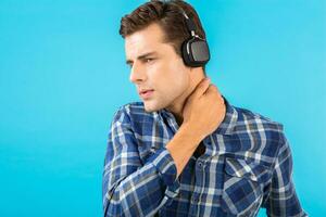 elegante joven hombre escuchando a música en inalámbrico auriculares foto