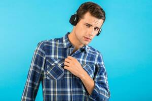 elegante joven hombre escuchando a música en inalámbrico auriculares foto