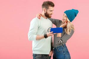 young attractive couple listening to music on wireless speaker photo