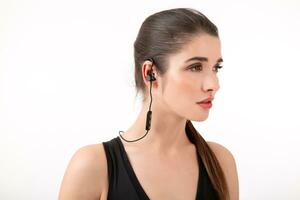 attractive woman in jogging black top listening to music on earphones photo