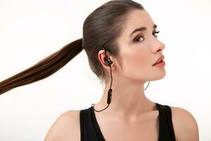 attractive woman in jogging black top listening to music on earphones photo