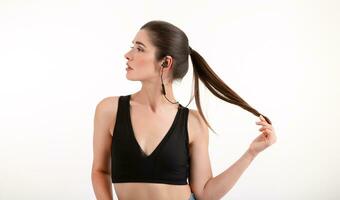 attractive woman in jogging black top listening to music on earphones photo