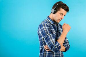 elegante joven hombre escuchando a música en inalámbrico auriculares foto