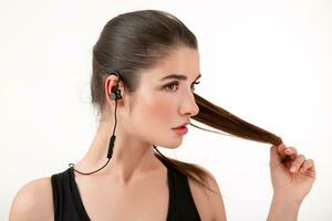 attractive woman in jogging black top listening to music on earphones photo