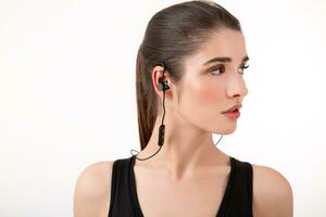 attractive woman in jogging black top listening to music on earphones photo