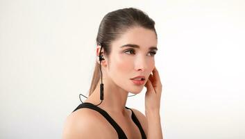 attractive woman in jogging black top listening to music on earphones photo