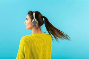 stylish young woman holding listening to music in headphones photo