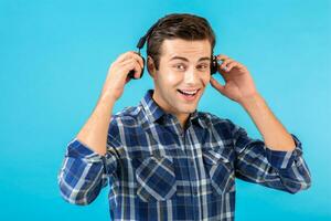 elegante joven hombre escuchando a música en inalámbrico auriculares foto