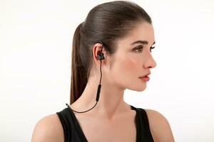 attractive woman in jogging black top listening to music on earphones photo