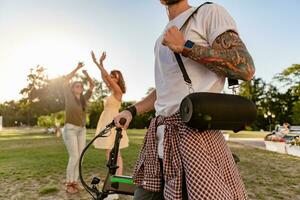 company of friends having fun together in park listening to music photo