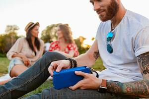 company of friends having fun together in park listening to music photo