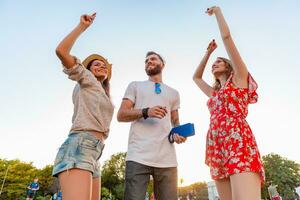 company of friends having fun together in park listening to music photo