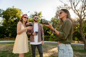 company of friends having fun together in park listening to music photo