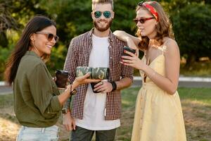 company of friends having fun together in park listening to music photo