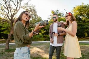 company of friends having fun together in park listening to music photo