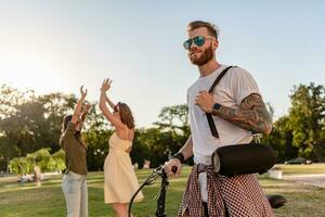 company of friends having fun together in park listening to music photo