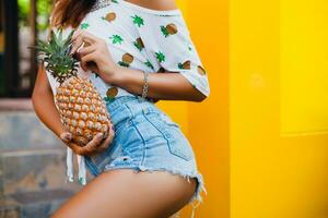 attractive smiling woman on vacation holding pineapple photo