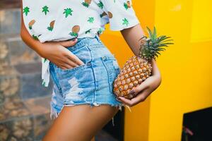 attractive smiling woman on vacation holding pineapple photo