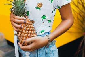 attractive smiling woman on vacation holding pineapple photo