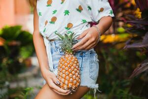 atractivo sonriente mujer en vacaciones participación piña foto