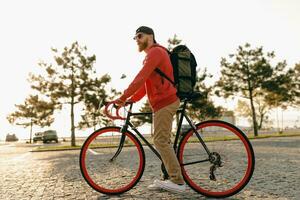 hermoso barbado hombre de viaje con bicicleta en Mañana foto