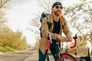 hermoso barbado hombre de viaje con bicicleta en Mañana foto