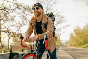 hermoso barbado hombre de viaje con bicicleta en Mañana foto