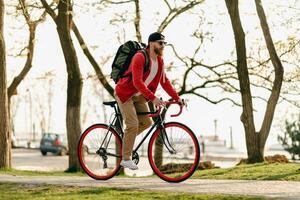 hermoso barbado hombre de viaje con bicicleta en Mañana foto