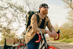 handsome bearded man traveling with bicycle in morning photo