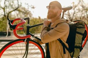 handsome bearded man traveling with bicycle in morning photo