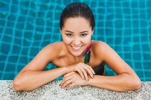 portrait of beautiful asian woman in black swimsuit bathing luxury spa swimming pool photo