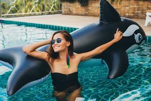 beautiful asian woman having fun in pool on tropical villa photo