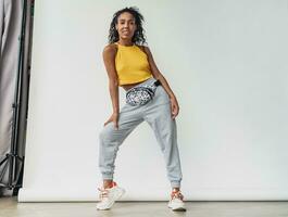 attractive black african american woman posing in stylish hipster outfit on white background photo