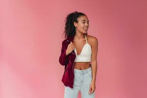 attractive black african american woman in stylish outfit on pink background photo