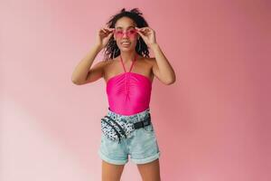 attractive black african american woman in stylish outfit on pink background photo