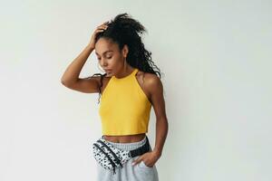 attractive black african american woman posing in stylish hipster outfit on white background photo